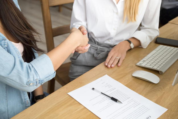 two-women-partners-handshaking-after-signing-business-contract-meeting_1163-4924